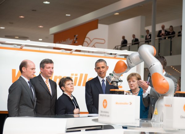 Bundeskanzlerin Angela Merkel (2.v.r, CDU) und US-Präsident Barack Obama (M) besuchen den Stand von Weidmüller auf der Hannover Messe und betrachten einen Roboter von Kuka. Die USA sind dieses Jahr das Partnerland der Messe. - © dpa