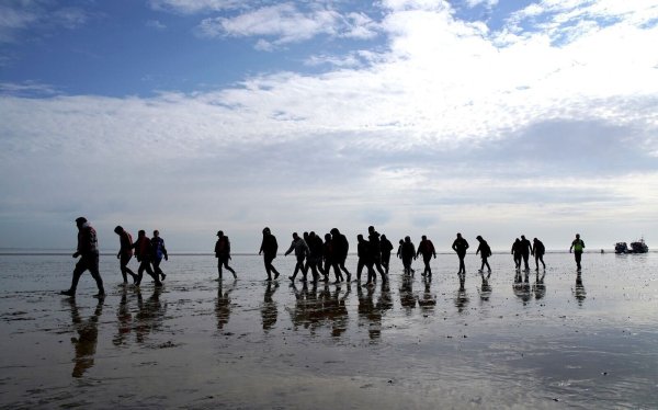 Mutmaßliche Migranten bei Dungeness, nachdem sie nach einem Zwischenfall mit einem kleinen Boot im Ärmelkanal mit einem Rettungsboot der Royal National Lifeboat Institution (RNLI) an Land gebracht wurden. - © Gareth Fuller/PA Wire/dpa