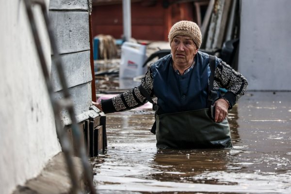 Eine Frau in der Nähe ihres Hauses in einem überschwemmten Gebiet in Orenburg, Russland. - © Uncredited/AP/dpa