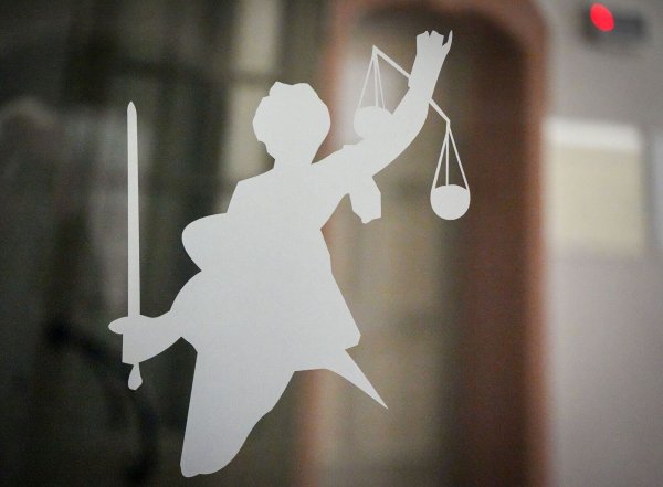 Die Figur der Justitia mit Richtschwert und Waage ist auf dem Glasfenster einer Tür im Gerichtsgebäude zu sehen. In Nordrhein-Westfalen gab es an den Gerichten erneut weniger Verurteilte. (Symbolbild) - © Soeren Stache/dpa