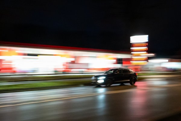 Ein Auto fährt am frühen Morgen an einer Tankstelle vorbei. - © Jonas Walzberg/dpa