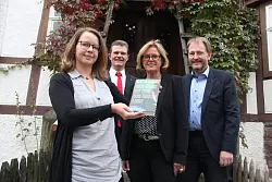 Freuen sich auf die Lesungen: Sarah Bloch, Arnd Paas, Ute Schäfer und Prof. Jan Carstensen vor dem Haus der jüdischen Familie Uhlmann, das im Freilichtmuseum steht. - © Barabara Luetgebrune