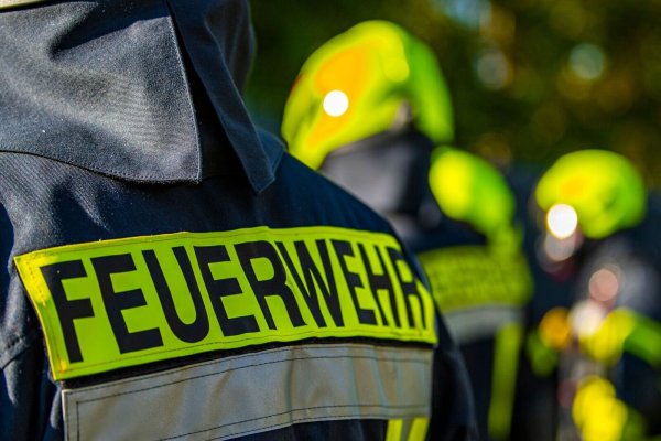 Feuerwehrleute stehen zusammen, um den Einsatz zu besprechen. - © David Inderlied/dpa/Symbolbild