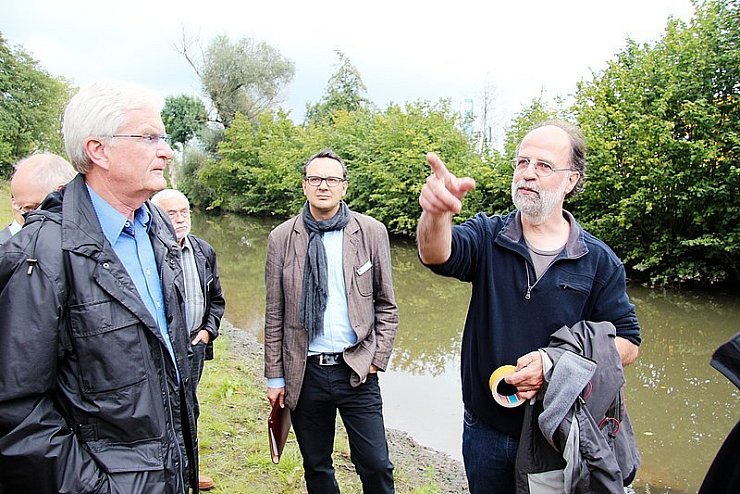 An der "neuen" Bega: Immo Henneberg (rechts) von der Stadtverwaltung erläutert die Renaturierung des Flusses. - © Foto: Reineke