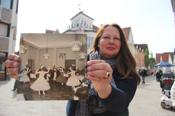 Vergangenheit trifft Gegenwart: Sabine Mirbach mit dem Bild eines „Tanztees" aus den 1950er Jahren. Auch im legendären „Rheingold" im Hintergrund fanden sie damals statt. - © Carolin Brokmann