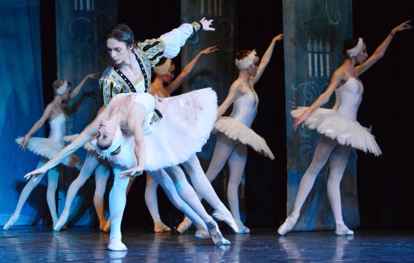 Mitreißende Liebesgeschichte: Prinz Siegfried (Timofey Fedorenko) und Prinzessin Odette (Anastasiia Abramova) tanzen auf der Bühne des Bad Meinberger Kurtheaters inmitten der Schwäne. - © André Gallisch