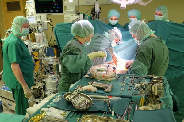 Jede Menge Gerätschaft: Die OP-Schwester (2. v. l.) reicht dem Chirurgen Michael Schönbrodt (3. v. l.) Scheren, Klemmen, Nadeln und Schalen an. Drei Medizinstudenten (im Hintergrund) beobachten die Operation. Links im Bild Kardiotechniker Kai Porschitz, der die Herz-Lungen-Maschine überwacht. - © Jörg Stuke