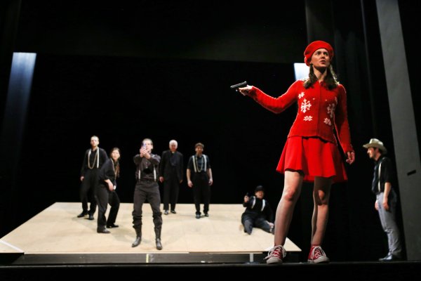 Rot trifft Schwarz-Weiß: Kathrin Berg in der Rolle der Elsi und weitere Mitglieder des Schauspielensembles in einer Probenszene für das Stück „Durcheinandertal". - © Landestheater Detmold/Mathias Rümmler