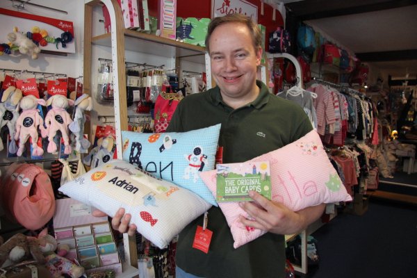 Stefan Heithecker präsentiert verschiedene Kissen und die Baby-Cards. - © Kirsten Fuhrmann