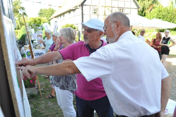 Informationen zur Nordumgehung: Karl-Ludwig Tracht von der Bürgerinitiative „Pro Ilsetal" (rechts) mit Besucher Gunter Voigt an einer Infotafel beim Sommerfest an der Steinmühle. - © Nicole Ellerbrake