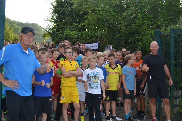 Sportliches Engagement: Schulleiter Karsten Fahrenkamp (rechts) wartet mit Schülern auf den Startschuss zum „Lauf gegen Rassismus" am Hermann-Vöchting-Gymnasium im August 2015. - © Dominic Behde