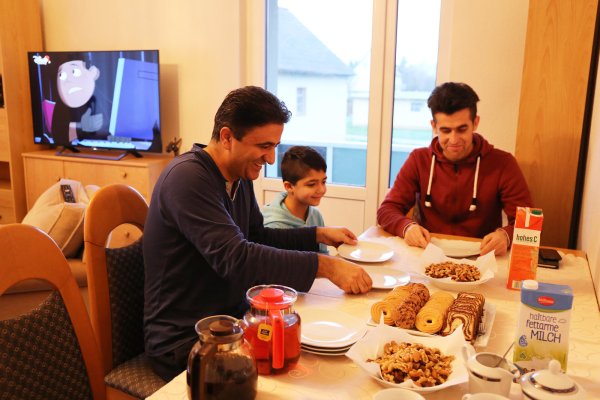 Frühstück mit dem Nachwuchs: Vater Afeez L. aus Afghanistan mit seinem neunjährigen Sohn. Dolmetscher Ikratullah Danial (rechts) ist ebenfalls dabei. - © Alina Hetland