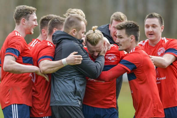 Kollektiver Torjubel: Regelrecht zerdrückt wird Patrick Siebert als Torschütze zum Führungstreffer von seinen Teamkollegen und Co-Trainer Dennis Wieder. In der Nachspielzeit schoss Siebert den 2:1-Siegtreffer. - © Egon Penner