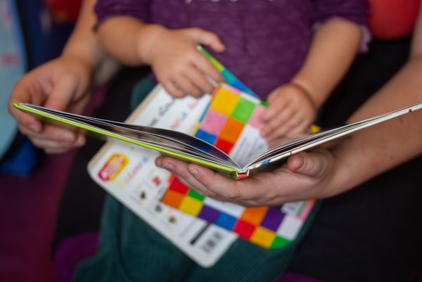 Eine Mutter liest ihrer kleinen Tochter im Kinderzimmer aus einem Buch vor. - © Fernando Gutierrez-Juarez/dpa