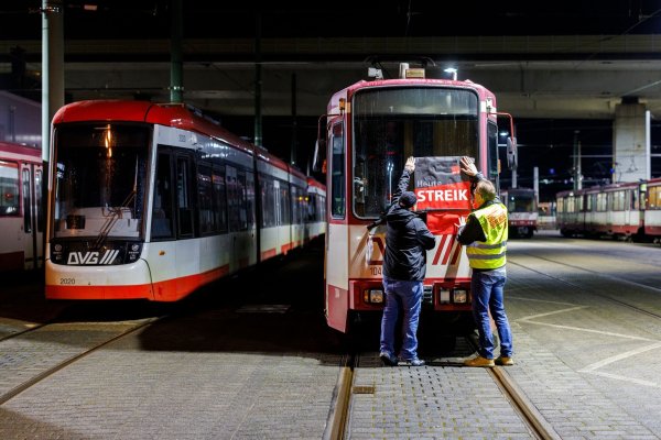 «Heute Streik» steht auf dem Plakat, dass Beschäftigte in Duisburg am frühen Morgen an eine Straßenbahn hängen. - © Christoph Reichwein/dpa