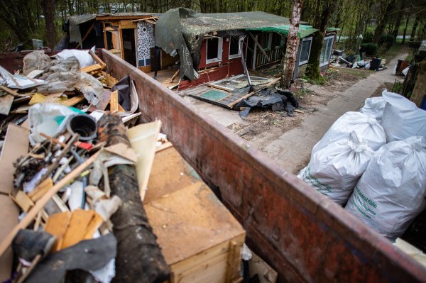 Eine Mulde steht vor der bereits zum Teil abgerissenen Parzelle des mutmaßlichen Täters auf dem Campingplatz Eichwald im Lügder Ortsteil Elbrinxen. Hier wurden erneut Datenträger gefunden. - © dpa