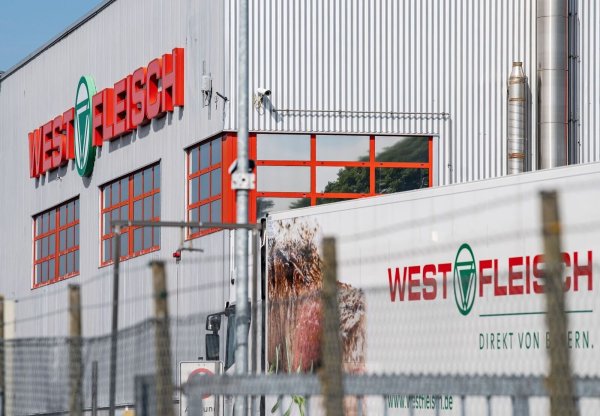 Ein LKW (r) des Fleischverarbeiters Westfleisch fährt auf das Firmengelände in Coesfeld. - © Guido Kirchner/dpa