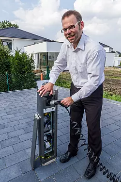 Phoenix-Contact-Mitarbeiter Jens Eickelmann betankt seinen BMW i3 mit Strom. 
- © Björn Leisten