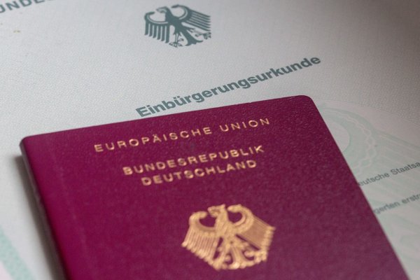 Eine Einbürgerungsurkunde von Deutschland und ein deutscher Reisepass liegen auf einem Tisch. - © Fernando Gutierrez-Juarez/dpa/Symbolbild