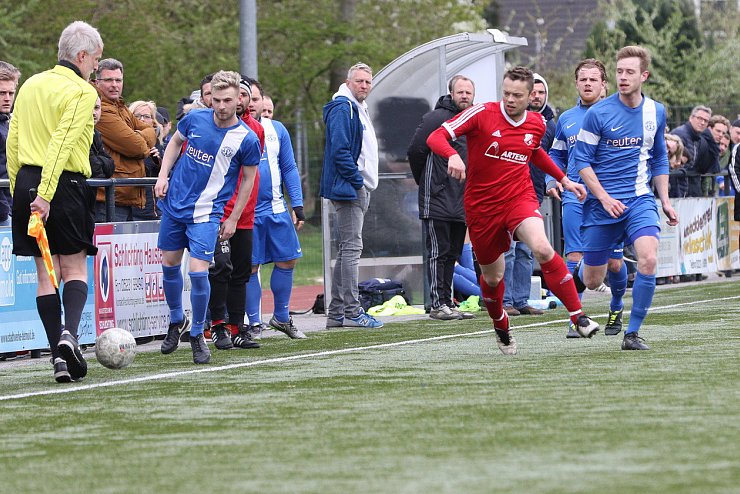Vor den Augen des Schiedsrichter-Assistenten und der vielen Zuschauer: Augustdorfs Alexander Eck (rotes Trikot) findet die Lücke zwischen den Jerxer Gegenspielern. - © Oliver König