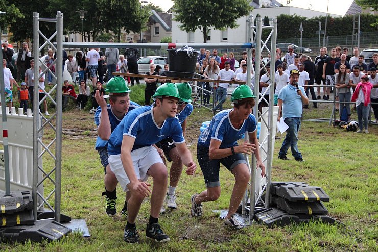 Dusche von oben: Vor den Augen zahlreicher Zuschauer balanciert das Stegelmann-Team beim Hafenfest in Schötmar gemeinsam einen Eimer Wasser. Schnippische Bemerkungen kann sich Moderator Manuel Dehnert nicht verkneifen.
FOTO: STORK - © Heidi Stork