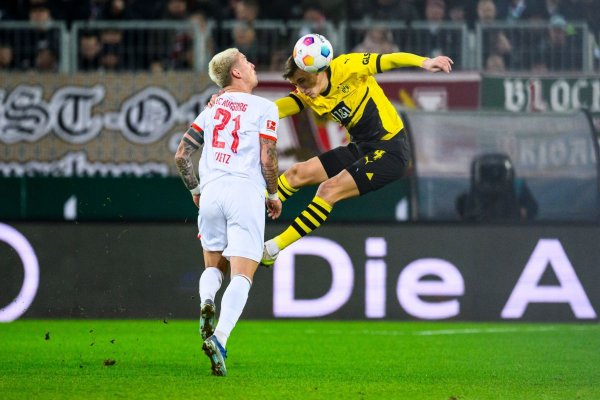 Dortmunds Nico Schlotterbeck (r) in Aktion gegen Augsburgs Phillip Tietz (l). - © Tom Weller/dpa