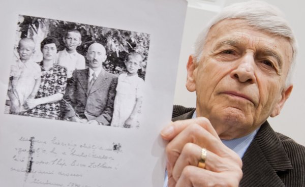 Der Auschwitz-Überlebende Max Eisen zeigt am 23.04.2015 im Gerichtssaal in Lüneburg (Niedersachsen) ein Foto aus dem Jahr 1940, welches ihn als Kind (3.v.l.) mit seinen Eltern und seinen Brüdern zeigt. 70 Jahre nach Ende der Nazi-Diktatur steht der frühere SS-Mann Oskar Gröning in Lüneburg vor Gericht. Die Anklage wirft ihm Beihilfe zum Mord im Vernichtungslager Auschwitz vor - in mindestens 300.000 Fällen. - © dpa