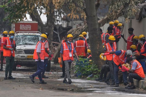 Arbeiter sind an der Absturzstelle im Einsatz. - © Rafiq Maqbool/AP/dpa