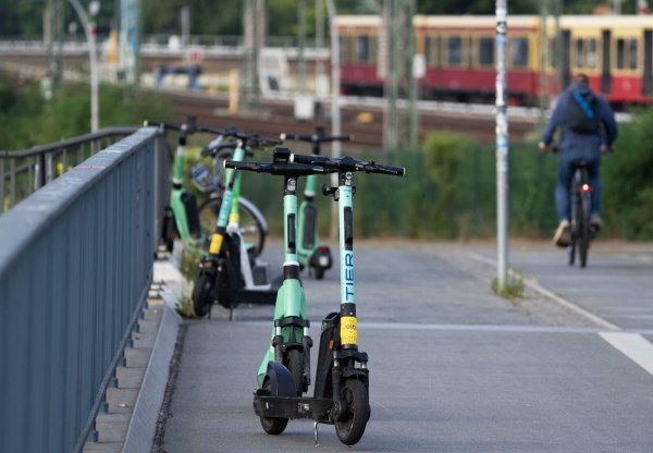 Elektroroller verschiedener Anbieter stehen nahe dem Berliner Bahnhof Ostkreuz auf einem Gehweg. - © Soeren Stache/dpa