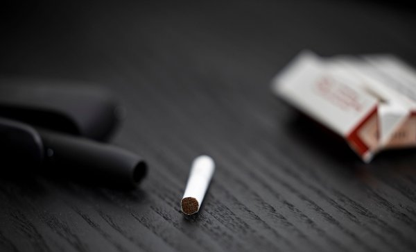 Ein Tabakstick, Stickpäckchen und Tabakerhitzer liegen auf einem Tisch. Die drei Branchenriesen haben hohe Erwartungen an den künftigen Absatz. - © Hannes P. Albert/dpa