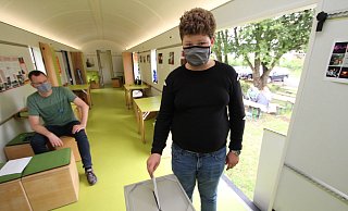 Wie bei den Großen läuft die Wahl im Jugendwaggon. Der 13-Jährige Justin wirft seinen Stimmzettel ein. Im Hintergrund: „Wahlhelfer" Jochen Brunsiek von der Landeseisenbahn. - Jens Rademacher