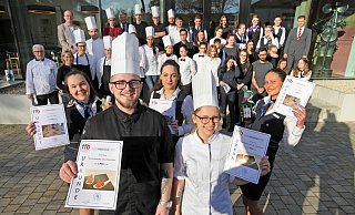 Garniert mit ihren hohen Mützen, stehen als beste Köche Matthias Büker und Lena Kendon vorn, gefolgt von den Siegern bei den Hotel- und Restaurantfachleuten Doreen Endryk, Chiara Castello und Silvija Tarutyke. Den Fonds bilden die weiteren Teilnehmer und Juroren. - Bernhard Preuss
