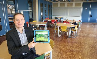 Oliver Dudek ist neuer Schulleiter der Gesamtschule Aspe. Er sitzt in Zeiten von Corona im Raum für die Notbetreuung für Kinder von Eltern aus systemrelevanten Berufen. Im Hintergrund sitzten Eileen (10, links) und ihre Zwillingsschwester Emily (10) aus der fünften Klasse über einigen Aufgaben. Ansonsten ist die Schule aktuell leer gefegt, die Schüler erhalten ihre Unterrichtsmaterialien in digitaler Form - etwa auf ihr Tablet. - Alexandra Schaller