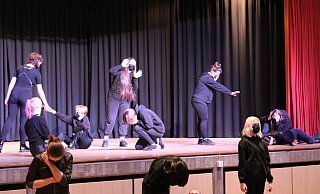 Ganz in Schwarz gekleidet übernehmen die Schüler der zehnten Jahrgangsstufe die Bühne. Sie zitieren lautstark Überlebende des Holocaust, während sie durch ihre Gesten tiefste Betroffenheit zeigten. - Philipp Kersten