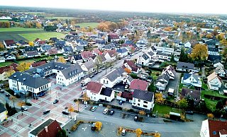 Die Parksituation am Rathaus aus der Vogelperspektive: Unten ein Teil des ehemaligen Jibi-Parkplatzes, gegenüber eine Reihe von Parkbuchten. Zudem kann, außer auf dem roten Platz, links und rechts an der Pivitsheider Straße geprakt werden. - Gemeinde Augustdorf