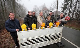 Schlänger fühlen sich durch die Sperre ausgegrenzt. Bodo Kibgies, Andre Pestrup, Heinrich Kuhlmeier, Henning Schwarze, Edeltraud Kuhlmeier, Maximilian Scholz und Dieter Vollmer haben sich fürs Foto hiter der Sperrbarke am Kreuzkrug versammelt. - Bernhard Preuss