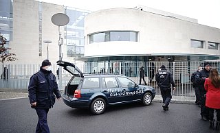 Ein Auto steht vor dem Tor des Bundeskanzleramts. Auf der Tür ist die Aufschrift «Stop der Globalisierungs-Politik» zu lesen. - Foto: Michael Kappeler/dpa Ein Auto steht vor dem Tor des Bundeskanzleramts. Auf der Tür ist die Aufschrift «Stop der Globalisierungs-Politik» zu lesen. - Foto: Michael Kappeler/dpa