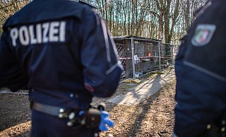 Auf dem Campingplatz Eichwald stehen vor der inzwischen eingezäunten Parzelle des mutmaßlichen Täters zwei Polizeibeamte. Nach der Verurteilung der beiden Hauptangeklagten im Missbrauchsfall von Lügde beginnt jetzt die parlamentarische Aufarbeitung. - Guido Kirchner/dpa