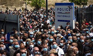 Zahlreiche Polizeibeamte und Zivilisten versammeln sich an einer Polizeistation, um dem getöteten Polizisten zu gedenken. - Foto: Daniel Cole/AP/dpa