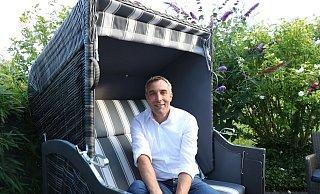 Dirk Tolkemitt sitzt im Strandkorb auf der kleinen Terrasse hinter seinem Einfamilienhaus in Kalletal-Stemmen. - Alexandra Schaller Dirk Tolkemitt sitzt im Strandkorb auf der kleinen Terrasse hinter seinem Einfamilienhaus in Kalletal-Stemmen. - Alexandra Schaller