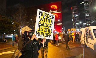 Eine Frau hält während eines Protests in Minneapolis ein Schild mit der Aufschrift «Murder with a badge is still murder» («Mord mit einer Dienstmarke ist immer noch Mord»). - Foto: Henry Pan/ZUMA Wire/dpa Eine Frau hält während eines Protests in Minneapolis ein Schild mit der Aufschrift «Murder with a badge is still murder» («Mord mit einer Dienstmarke ist immer noch Mord»). - Foto: Henry Pan/ZUMA Wire/dpa