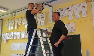 Machen die Grundschule fit fürs schnelle Internet. Louis Rehm (links) und Michael Pramschüfer von der Gebäudewirtschaft ziehen an der Grundschule Kirchheide die Kabel.  - Katrin Kantelberg(LZ)
