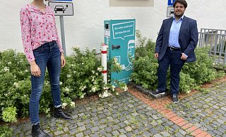SPD-Ratsfrau Hannah Penke posiert mit dem Bürgermeisterkandidaten der Sozialdemokraten, Julian Koch, vor der Ladestation am Rathaus. - SPD Schlangen