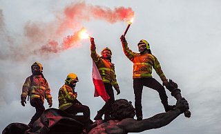 Feuerwehrleute sind in Paris bei einem weiteren Protest gegen die Rentenreform in Frankreich auf ein Denkmal geklettert und halten rote Fackeln in die H&ouml;he. - Foto: Sadak Souici/Le Pictorium Agency via ZUMA/dpa