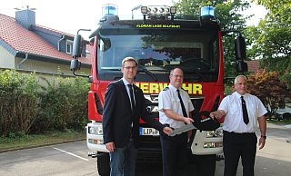 Bürgermeister Matthias Kalkreuter ( von links) übergibt den symbolischen Schlüssel an den Lagenser Feuerwehrchef Benjamin Brinkmeyer und den Abteilungsleiter in Heiden Carsten Drewes. - Nadine Uphoff