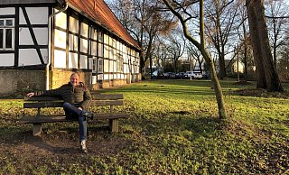 Hans-Joachim Lücking sitzt im Park mit den alten Bäumen am ehemaligen Jugendzentrum „Das Haus" in Holzhausen. Das Areal könnte sich mit EU-Geldern zu einem Dorfmittelpunkt entwickeln. Dafür will sich der Ortsausschussvorsitzende einsetzen. Foto: Thomas Reineke - Thomas Reineke