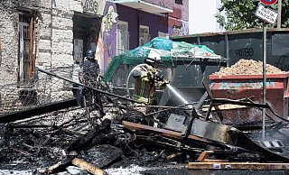 Ein Feuerwehrmann löscht eine brennende Barrikade in der Rigaer Straße in Berlin-Friedrichshain. - Foto: Paul Zinken/dpa-Zentralbild/dpa Ein Feuerwehrmann löscht eine brennende Barrikade in der Rigaer Straße in Berlin-Friedrichshain. - Foto: Paul Zinken/dpa-Zentralbild/dpa