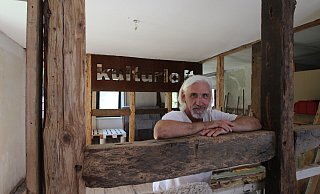 Guido Weikert will in einem alten Bruchstein-Fachwerkhaus in Humfeld ein "Kulturloft" einrichten und sich gleichzeitig dem "bedingungslosen Geben" widmen. Im Hintergrund sind ein Klavier und eine improvisierte Bühne zu sehen. - Jens Rademacher