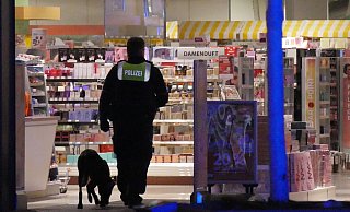 Mit einem Sp&uuml;rhund kontrolliert die Polizei nach Ausl&ouml;sung der Diebstahlwarnanlage im M&uuml;ller, ob noch Personen im Gesch&auml;ft sind. - Jost Wolf