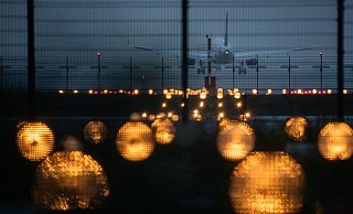 Ein Flugzeug landet hinter Signallichtern auf einem Flughafen. - Sebastian Gollnow/dpa/Symbolbild Ein Flugzeug landet hinter Signallichtern auf einem Flughafen. - Sebastian Gollnow/dpa/Symbolbild